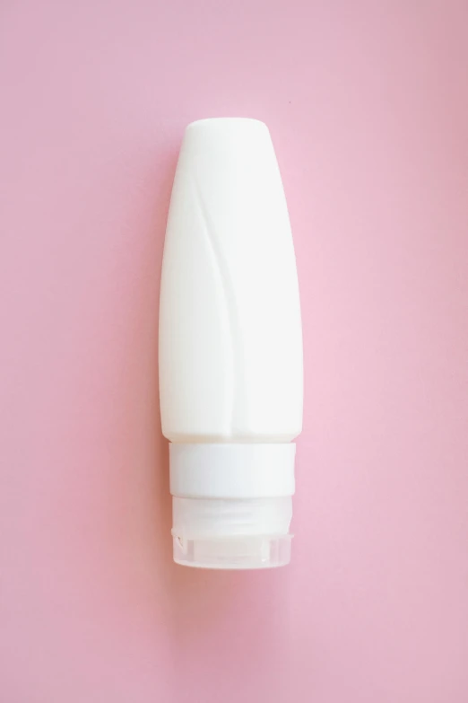 a bottle of lotion sitting on a pink surface, a picture, by Julian Allen, shutterstock, plasticien, white sleeves, made of plastic, half body photo, cone shaped