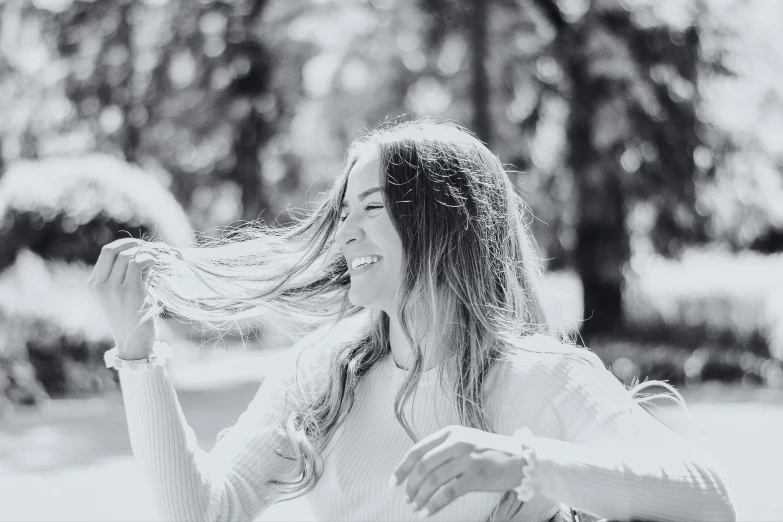 a black and white photo of a woman sitting on a bench, a black and white photo, pexels contest winner, happening, smiling and dancing, wind in long hair, promotional image, happy friend