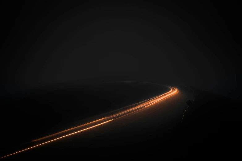 a car driving down a road at night, inspired by Michal Karcz, unsplash contest winner, minimalism, curving, running lights, amanda lilleston, orange lights