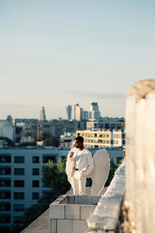 a man in a white suit standing on top of a building, girl with angel wings, shot with sony alpha, ukraine. photography, photograph of san francisco