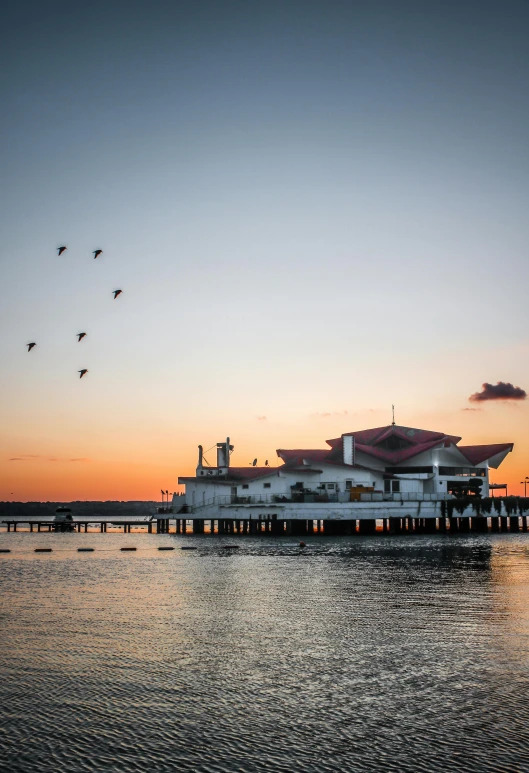 a pier with birds flying over it at sunset, by Jan Tengnagel, floating palace, 4k photo”, f / 1 6, museum quality photo