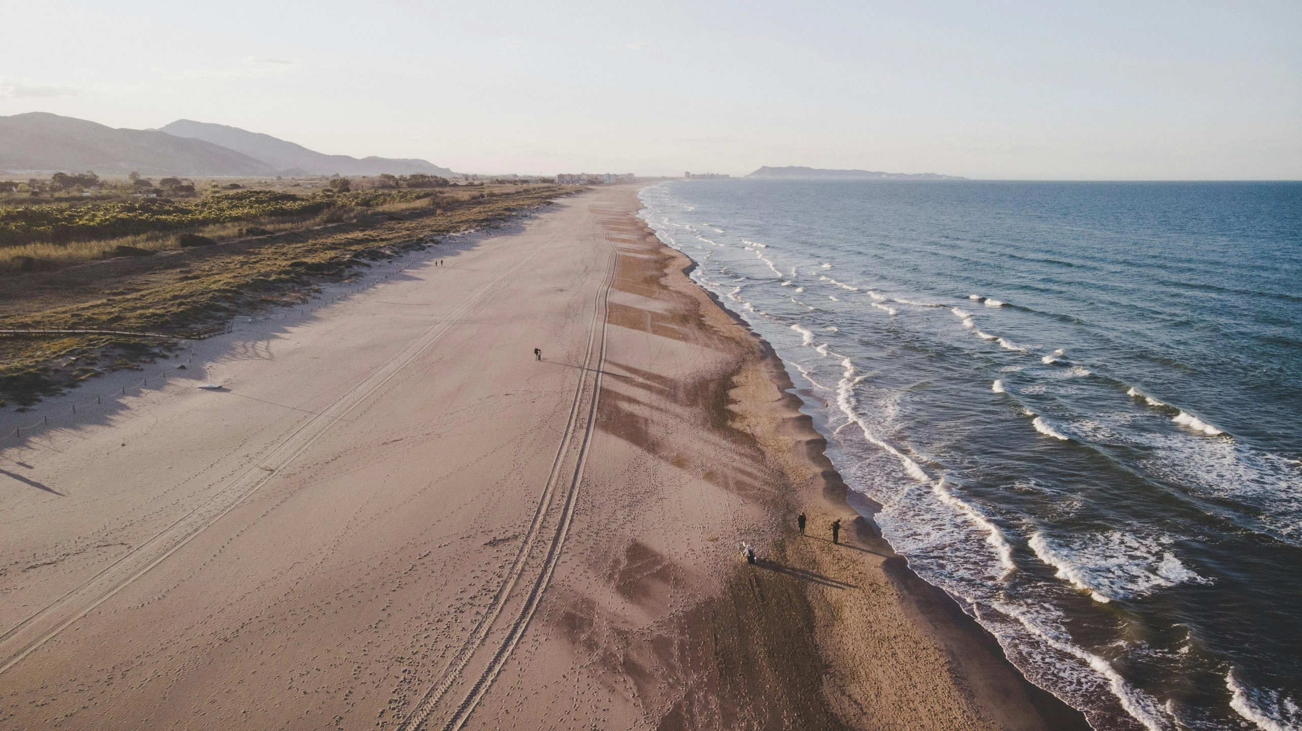 a group of people walking along a beach next to the ocean, pexels contest winner, aerial footage, albuquerque, clean long lines, 2 5 6 x 2 5 6 pixels