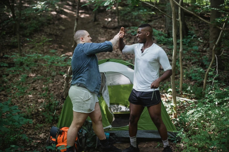 two men standing next to each other near a tent, pexels contest winner, white shorts and hiking boots, dancing with each other, william penn state forest, lgbtq