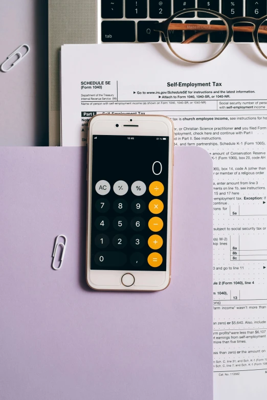 a calculator sitting on top of a desk next to a laptop, by Robbie Trevino, pexels, corporate phone app icon, yellow and purple color scheme, selfie photo, documents