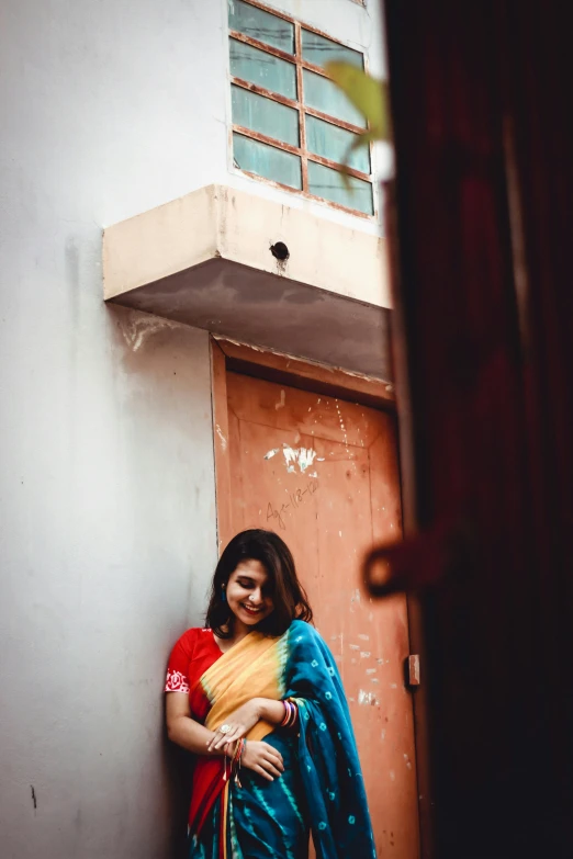 a woman in a sari leaning against a wall, pexels contest winner, happening, contrasting colors, teenage girl, looking around a corner, promo image