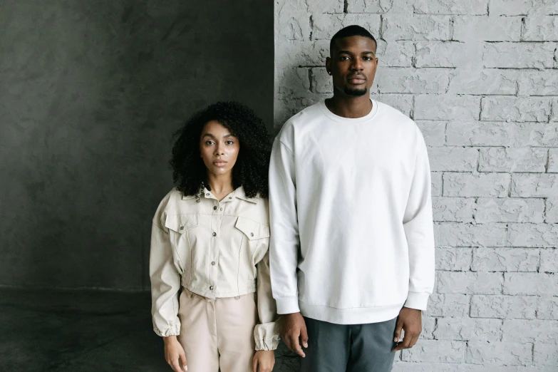 a man and a woman standing next to each other, trending on pexels, wearing a white sweater, off - white collection, portrait 8 k, gray canvas