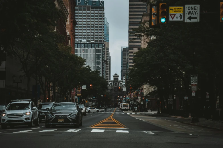 a street filled with lots of traffic next to tall buildings, a photo, by Carey Morris, pexels contest winner, new jersey, 🚿🗝📝, prefecture streets, car shot