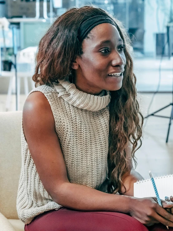 a woman sitting on a couch talking to another woman, by Arabella Rankin, pexels contest winner, sleeveless turtleneck, sza, headshot profile picture, sitting at a desk