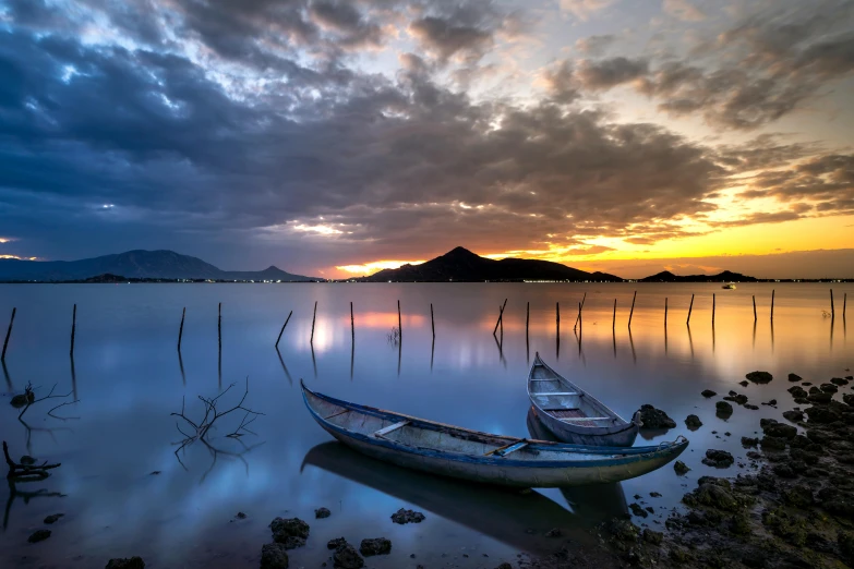 a boat sitting on top of a body of water, by Ibrahim Kodra, unsplash contest winner, romanticism, vietnam, calm evening, lagoon, floods