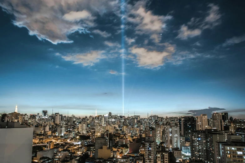 a view of a city from the top of a building, by Luis Miranda, pexels contest winner, conceptual art, drag light bombs, halo of light, oscar niemeyer, 9 / 1 1