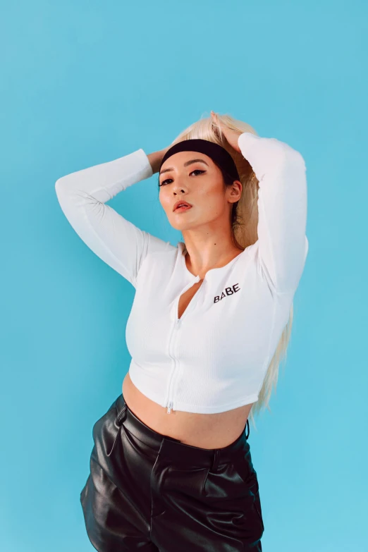 a woman in a white shirt and black leather pants, an album cover, inspired by Wang E, trending on pexels, wearing a crop top, white ponytail hair, outlive streetwear collection, satisfied pose