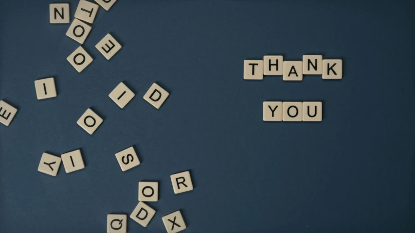 the word thank you spelled in scrabbles on a blue surface, a picture, by Emma Andijewska, letterism, dark. no text, tan, restoration, on grey background
