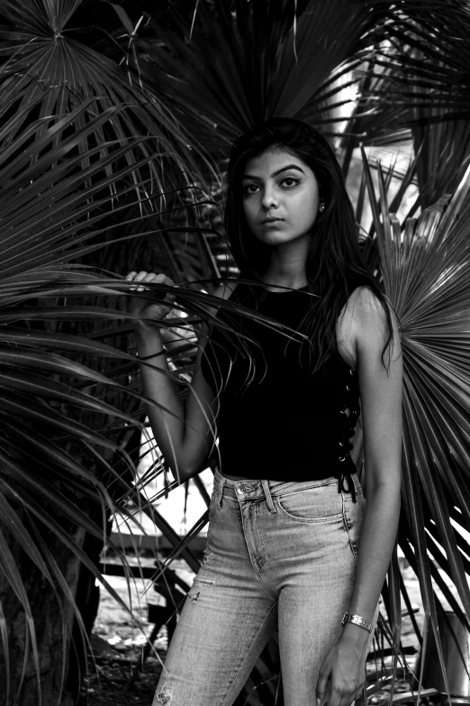 a woman standing in front of a palm tree, a black and white photo, by Max Dauthendey, 19-year-old girl, jayison devadas, mia khalifa, with a bewitching voice