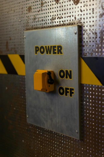 a close up of a power button on a metal wall, by John Covert, pexels, worksafe. dramatic, laser cut, thumbnail, yellow
