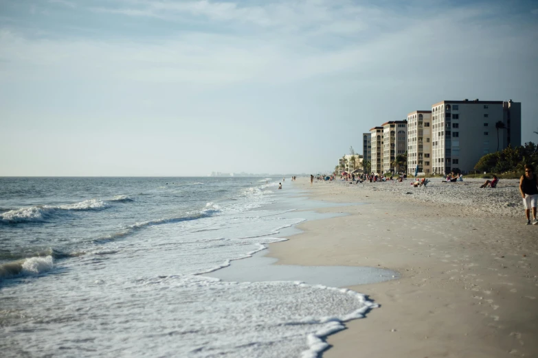 a group of people walking along a beach next to the ocean, by Carey Morris, pexels contest winner, savannah, seen from afar, myrtle, pristine and clean