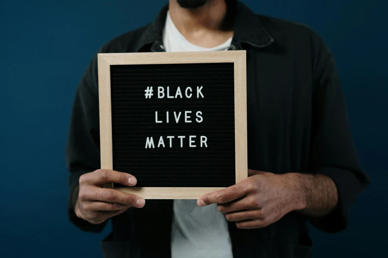 a man holding a sign that says black lives matter, trending on unsplash, main colour - black, background image, instagram picture, thumbnail