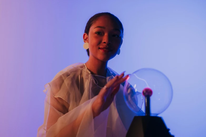 a woman holding a crystal ball in her hands, an album cover, inspired by Ai-Mitsu, unsplash, kinetic art, joy ang, cathode ray tube, promotional photo, tactile buttons and lights