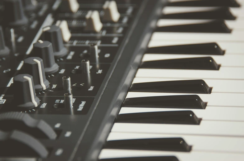 a close up of a keyboard with many keys, an album cover, unsplash, bass sound waves on circuitry, simple stylized, synthesizers, dark and white