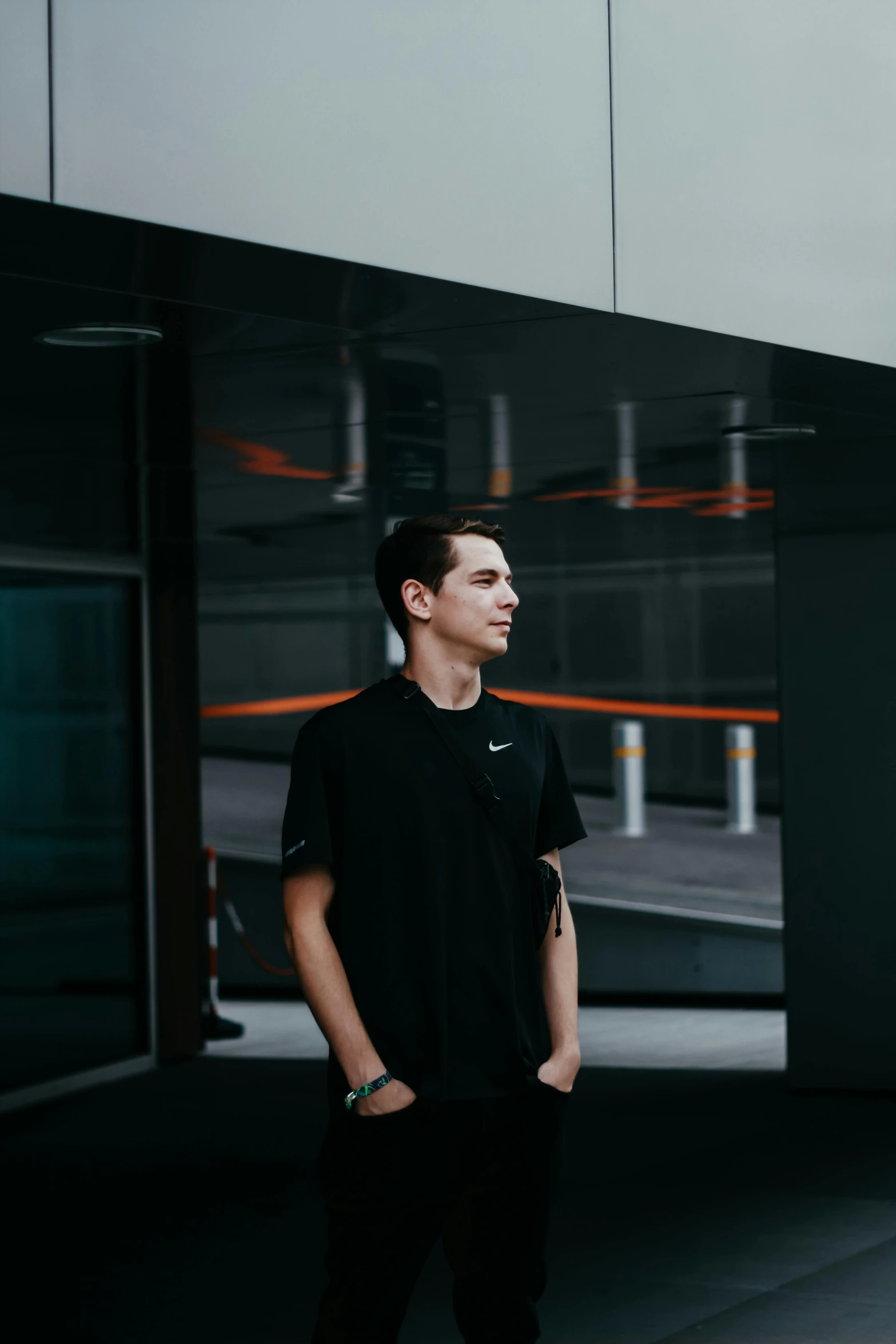 a man standing in front of a building, wearing a black tshirt, minimalistic background, dylan kowalski, avatar image