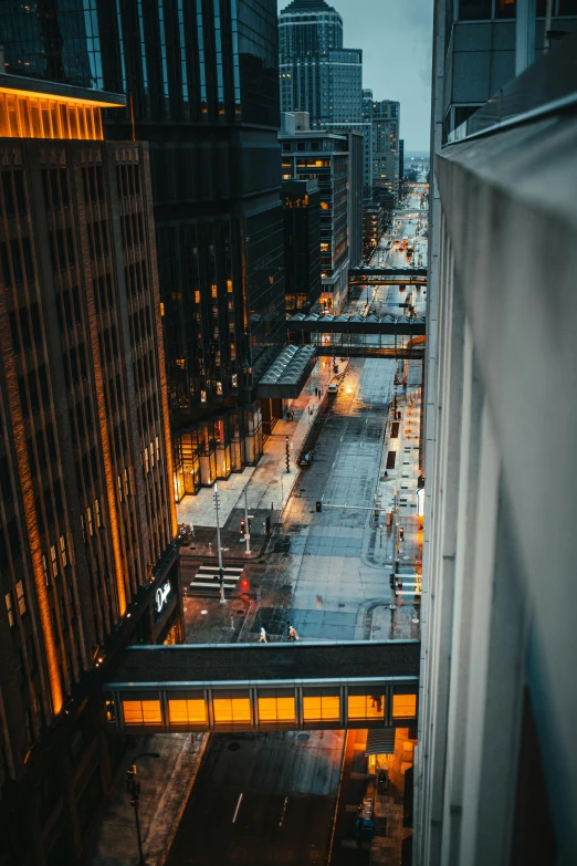 a view of a city at night from a high rise building, by Dan Christensen, modern chicago streets, dusk on a city street, high-quality photo, streetlamps with orange light