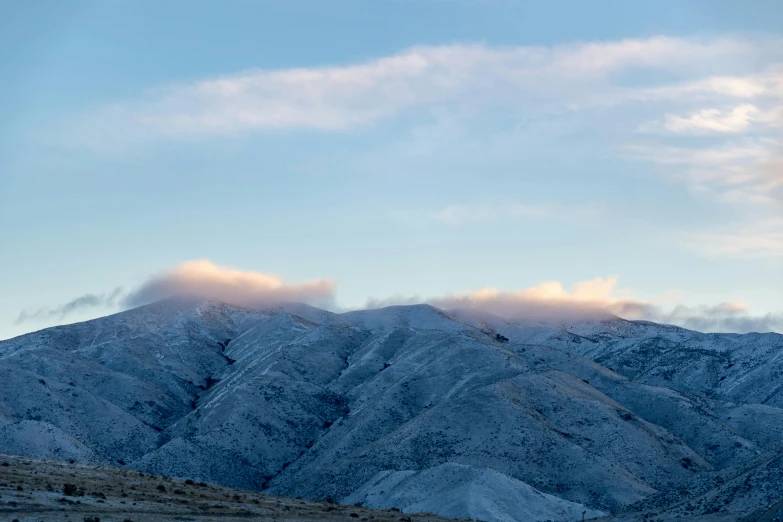 a person flying a kite on top of a snow covered mountain, light pink clouds, winter photograph, new zealand, today\'s featured photograph 4k