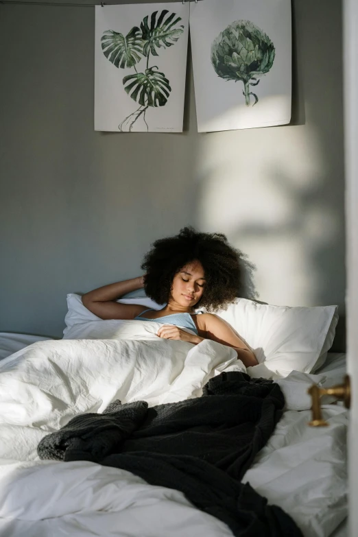 a woman laying in bed with a white comforter, trending on pexels, goddess checking her phone, black young woman, soft sunbeam, in small room