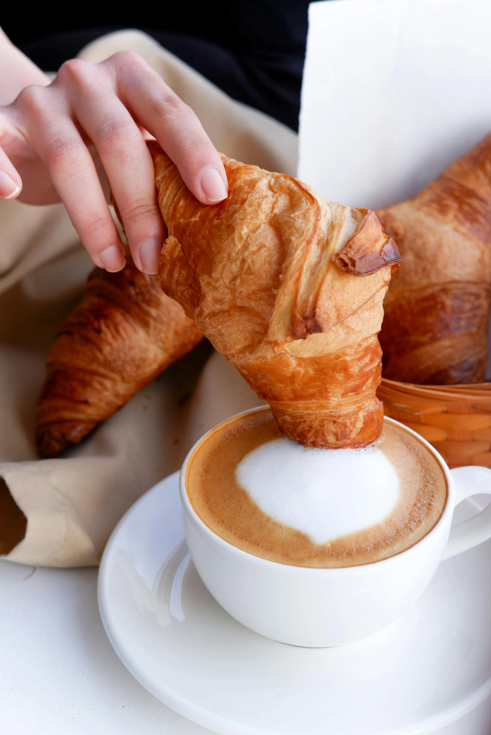 a person holding a croissant over a cup of coffee, vine twist, sleek hands, aussie baristas, award - winning crisp details ”