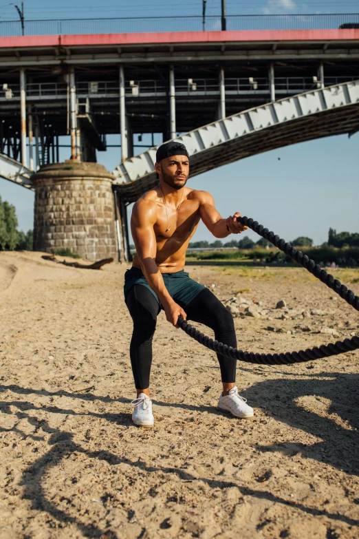 a man that is standing in the sand with a rope, wearing fitness gear, kreuzberg, 2019 trending photo, charts