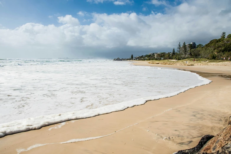 a man riding a surfboard on top of a sandy beach, sarenrae, landscape photo, uncropped, round-cropped