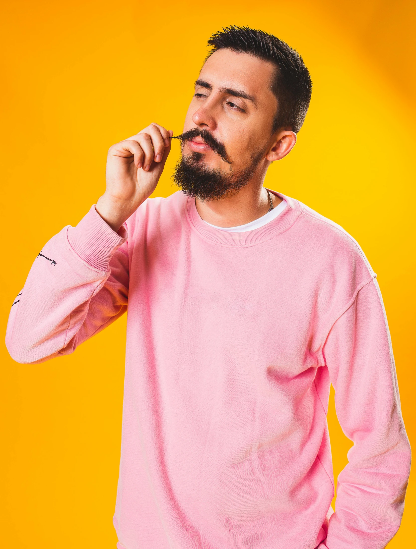 a man with a beard talking on a cell phone, inspired by David Begbie, trending on pexels, hyperrealism, pink clothes, yellow backdrop, smoking a joint, wearing sweatshirt