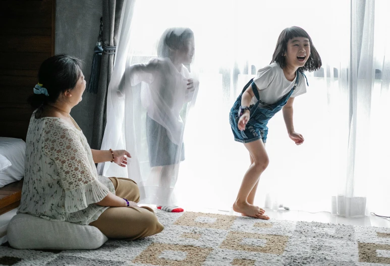 a woman and a little girl playing a video game, inspired by Ni Duan, pexels contest winner, visual art, covered in transparent cloth, girl is running, joyful people in the house, people watching around