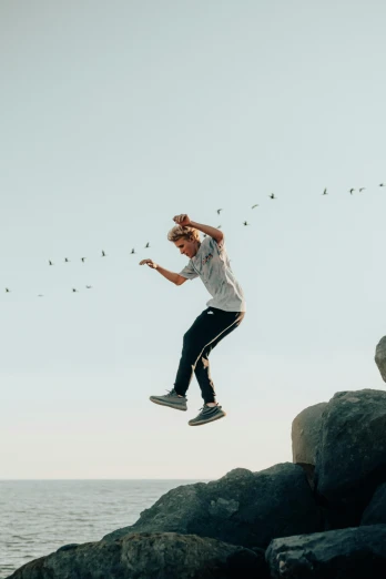a man flying through the air while riding a skateboard, a picture, pexels contest winner, happening, standing on rock, birds flying away, lil peep, quicksilver