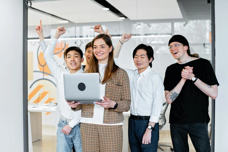 a group of people standing around a laptop, hero pose, not japanese, artsationhq, in an office