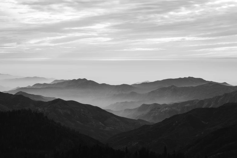 a black and white photo of a mountain range, by Kristian Zahrtmann, unsplash contest winner, southern california, visible layers, early morning, shades of grey