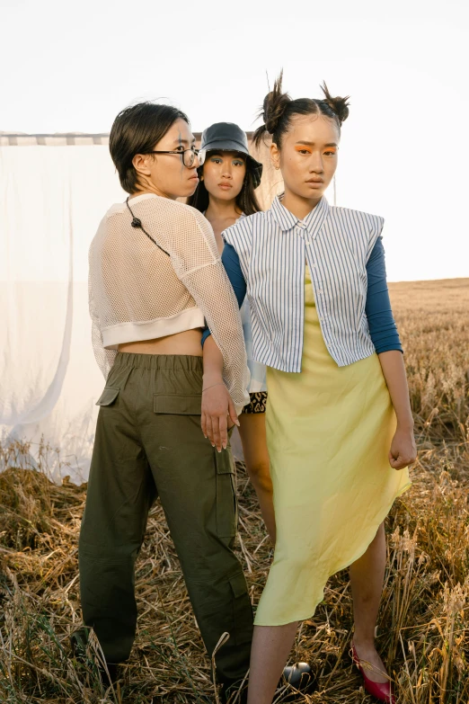 a group of women standing next to each other in a field, a picture, inspired by Kim Tschang Yeul, gutai group, crop top, wearing farm clothes, three women, at a fashion shoot