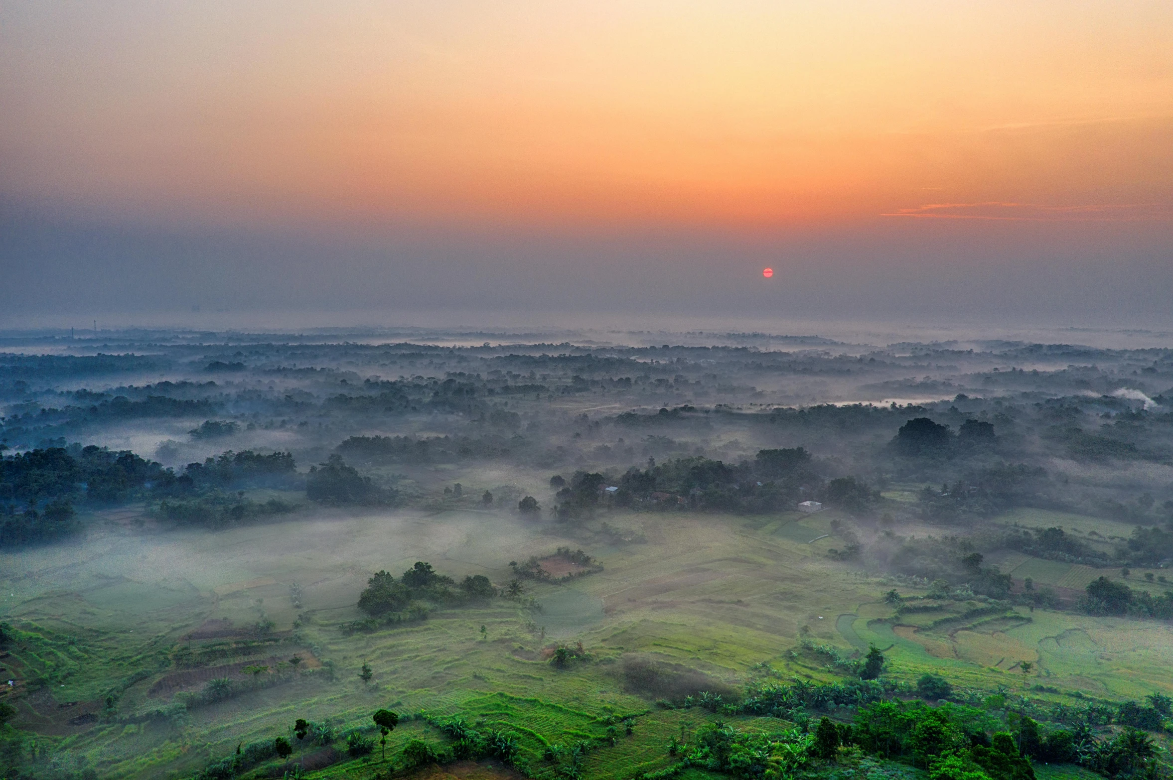 the sun is setting over a foggy valley, by Adam Marczyński, pexels contest winner, sumatraism, sri lankan landscape, aerial view of an ancient land, fine art print, farmland