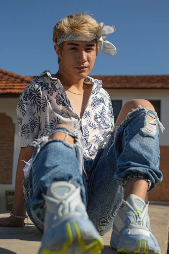 a young man sitting on top of a skateboard, by Robbie Trevino, trending on pexels, photorealism, kawaii shirt and jeans, non binary model, ( ( ( ( kauai ) ) ) ), wearing farm clothes