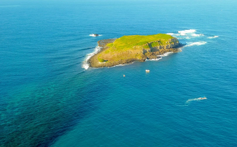 a small island in the middle of the ocean, by Simon Marmion, pexels contest winner, white head, te pae, wide high angle view, mid morning lighting