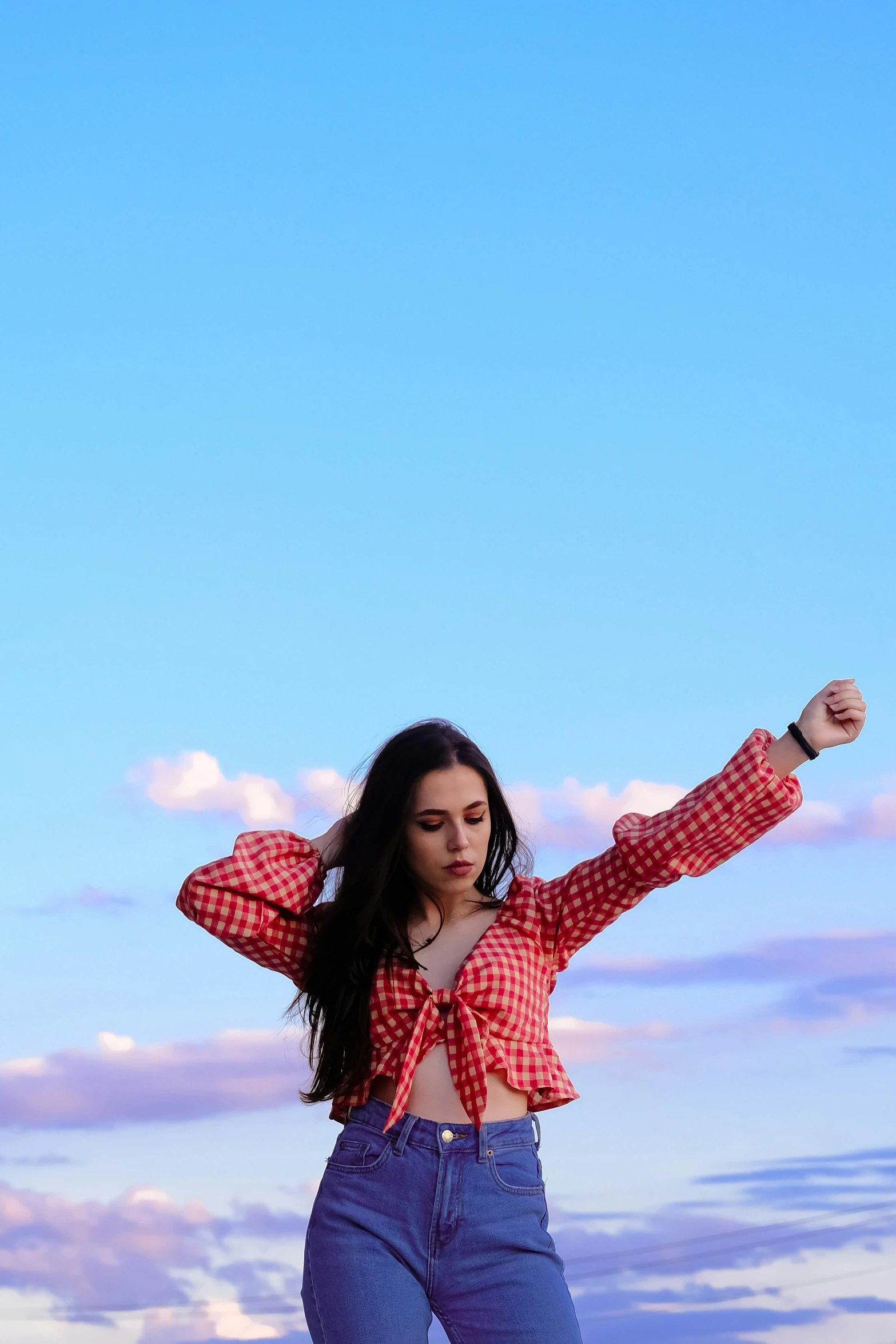 a woman standing on top of a lush green field, an album cover, trending on pexels, arabesque, wearing a plaid shirt, red sky blue, doing a hot majestic pose, wearing a cropped top