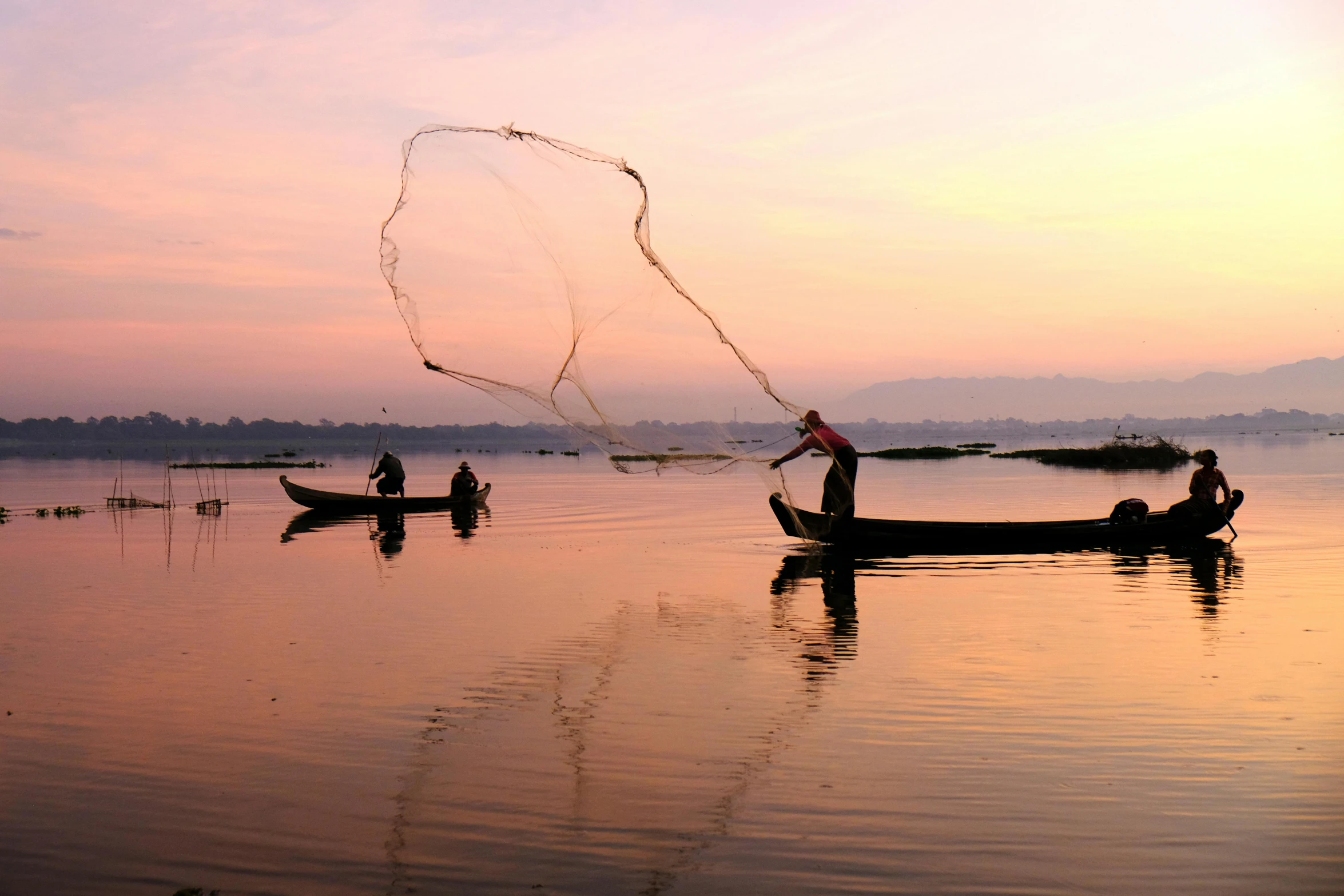 a group of people on a boat with a net, inspired by Steve McCurry, pexels contest winner, wide river and lake, fishes, dawn setting, 3 boat in river