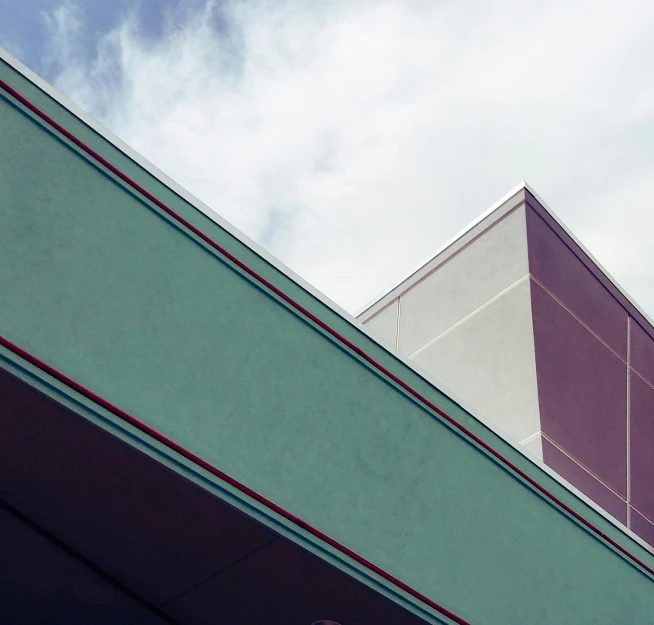 a clock that is on the side of a building, an album cover, unsplash, brutalism, mauve and cinnabar and cyan, classic cinema, 3/4 view from below, large overhangs