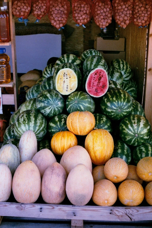 a pile of fruit sitting on top of a wooden crate, watermelons, storefronts, slide show, in 2 0 0 2