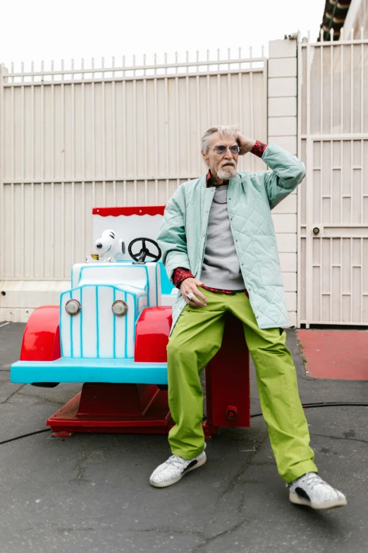 a man sitting on top of a toy truck, unsplash, magic realism, very long silver beard, wearing a track suit, theme park, green corduroy pants
