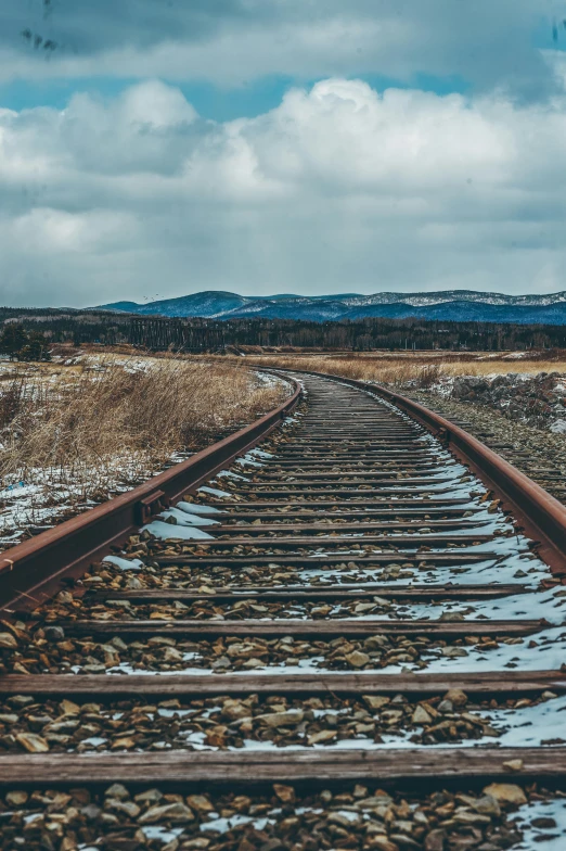 a train track in the middle of nowhere, unsplash contest winner, 🚿🗝📝, plain background, winter setting, hills in the background