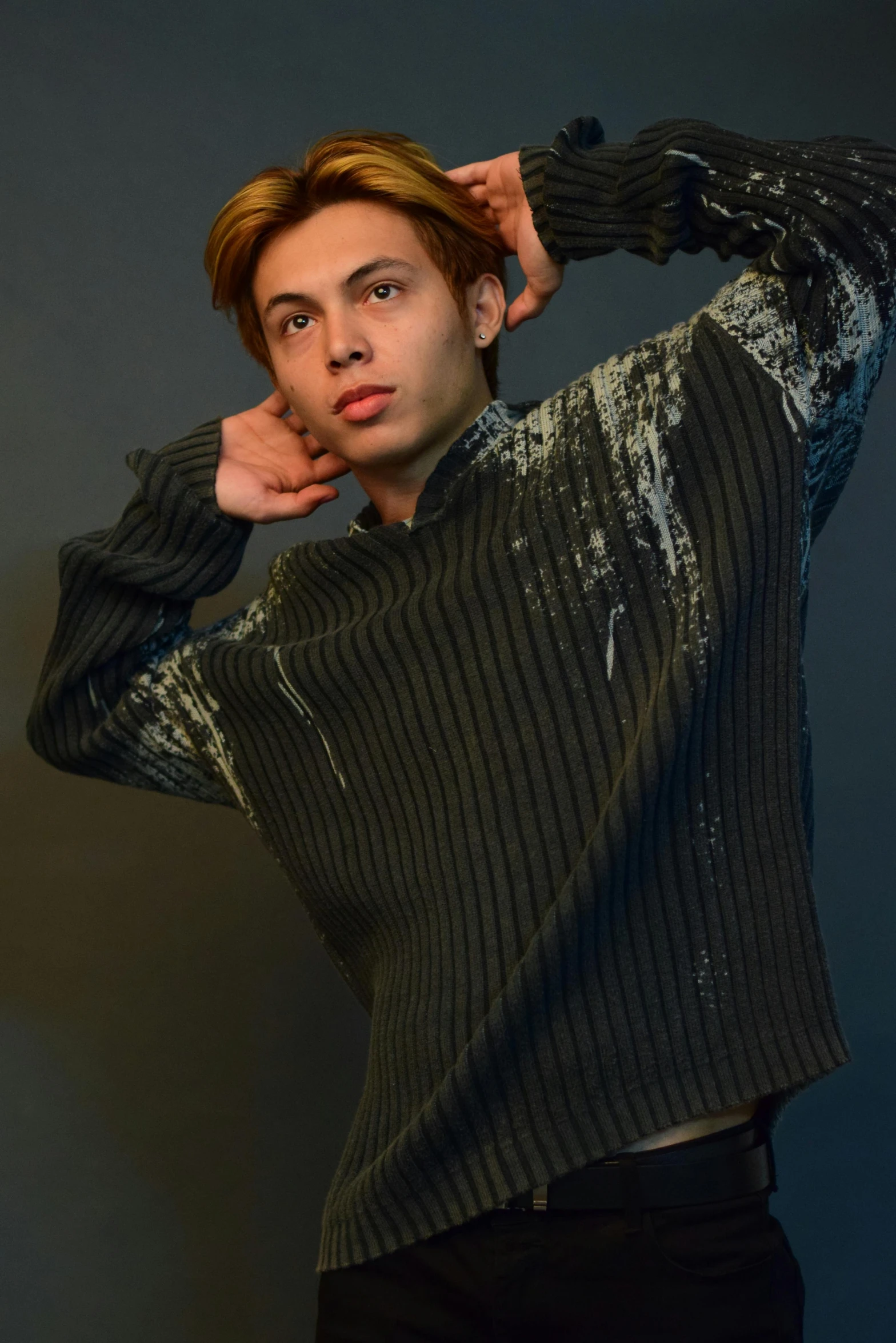 a man in a sweater posing for a picture, by Robbie Trevino, glossy and drippy, tattered clothing, promo image, male teenager