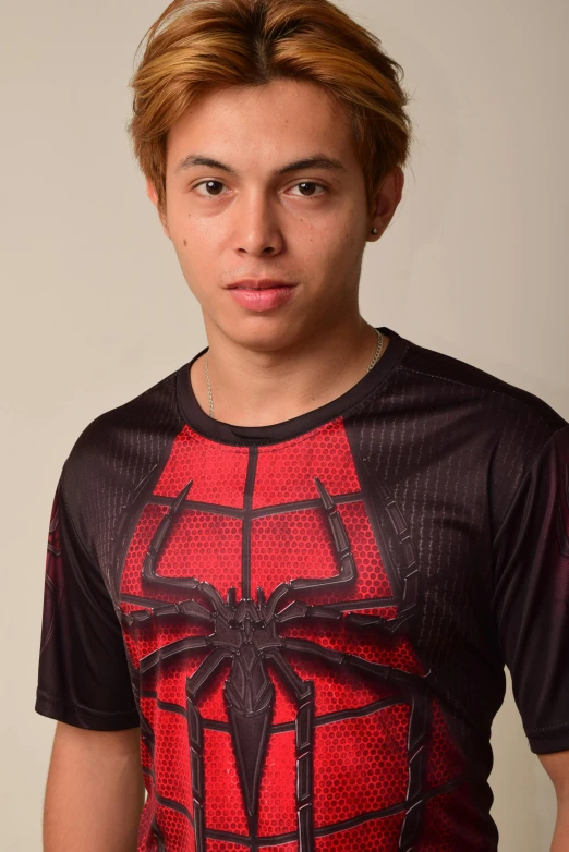 a young man wearing a spider - man t - shirt, by Robbie Trevino, shin hanga, black shirt underneath armor, joseph moncada, light stubble with red shirt, in 2 0 1 5