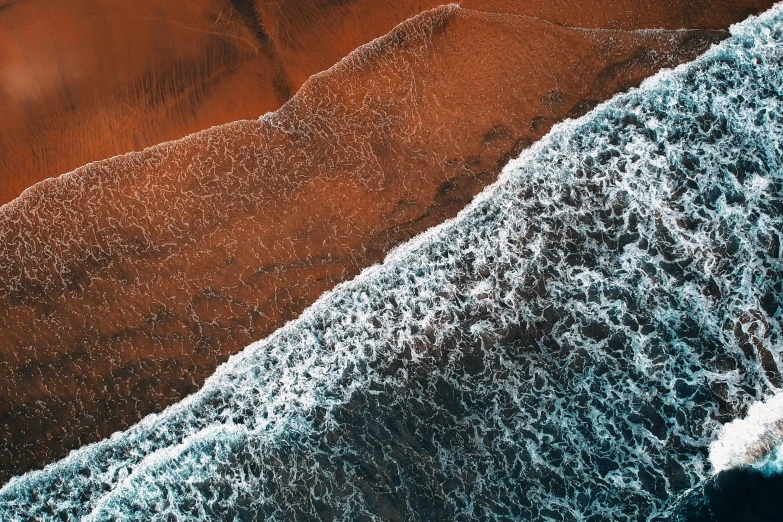 a large body of water next to a sandy beach, unsplash contest winner, generative art, burnt sienna and cerulean blue, birdseye view, ocean wave, both bright and earth colors