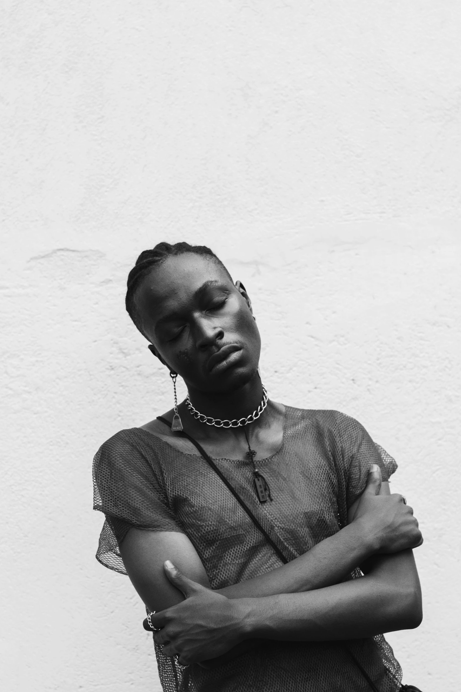 a black and white photo of a woman leaning against a wall, an album cover, inspired by Ras Akyem, trending on pexels, playboi carti portrait, attractive androgynous humanoid, a very sad man, adut akech