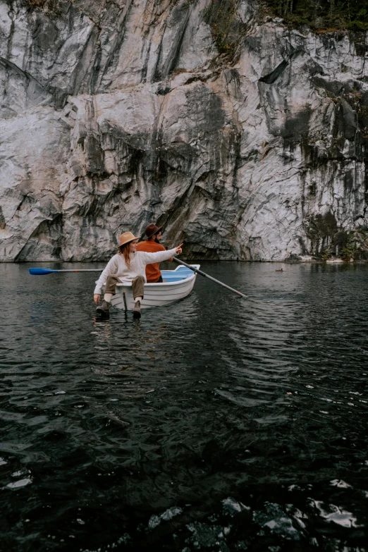 a person in a boat in a body of water, rock quarry location, fishing, lush surroundings, cliffs