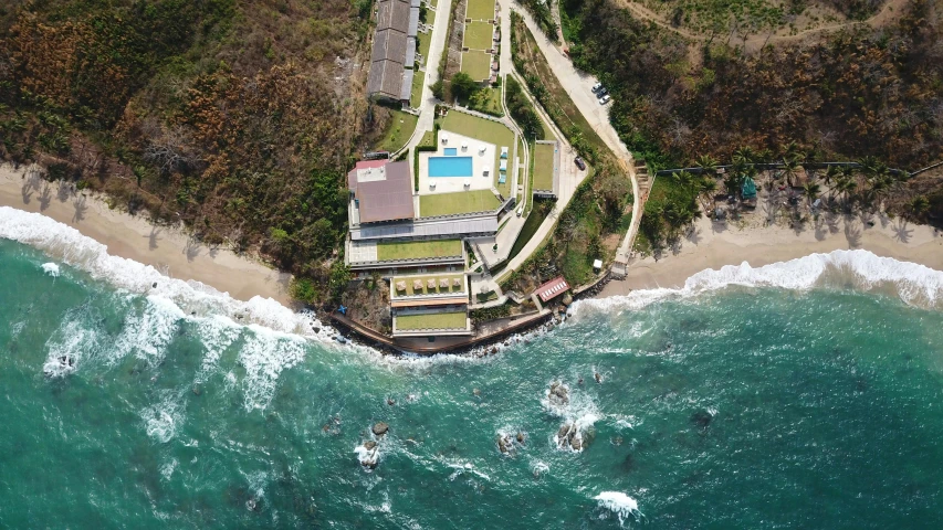 an aerial view of a house on the beach, a digital rendering, pexels contest winner, renaissance, helipad, mexico, cliffside, school